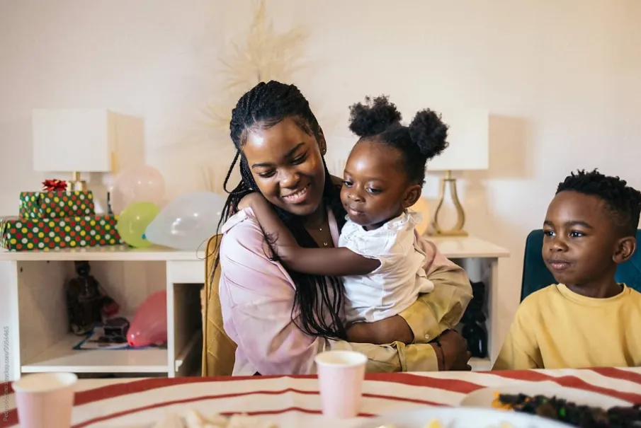 Family celebrating with gifts and balloons in a cozy room