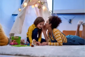 Kids sharing a secret in a cozy tent with toys around them.